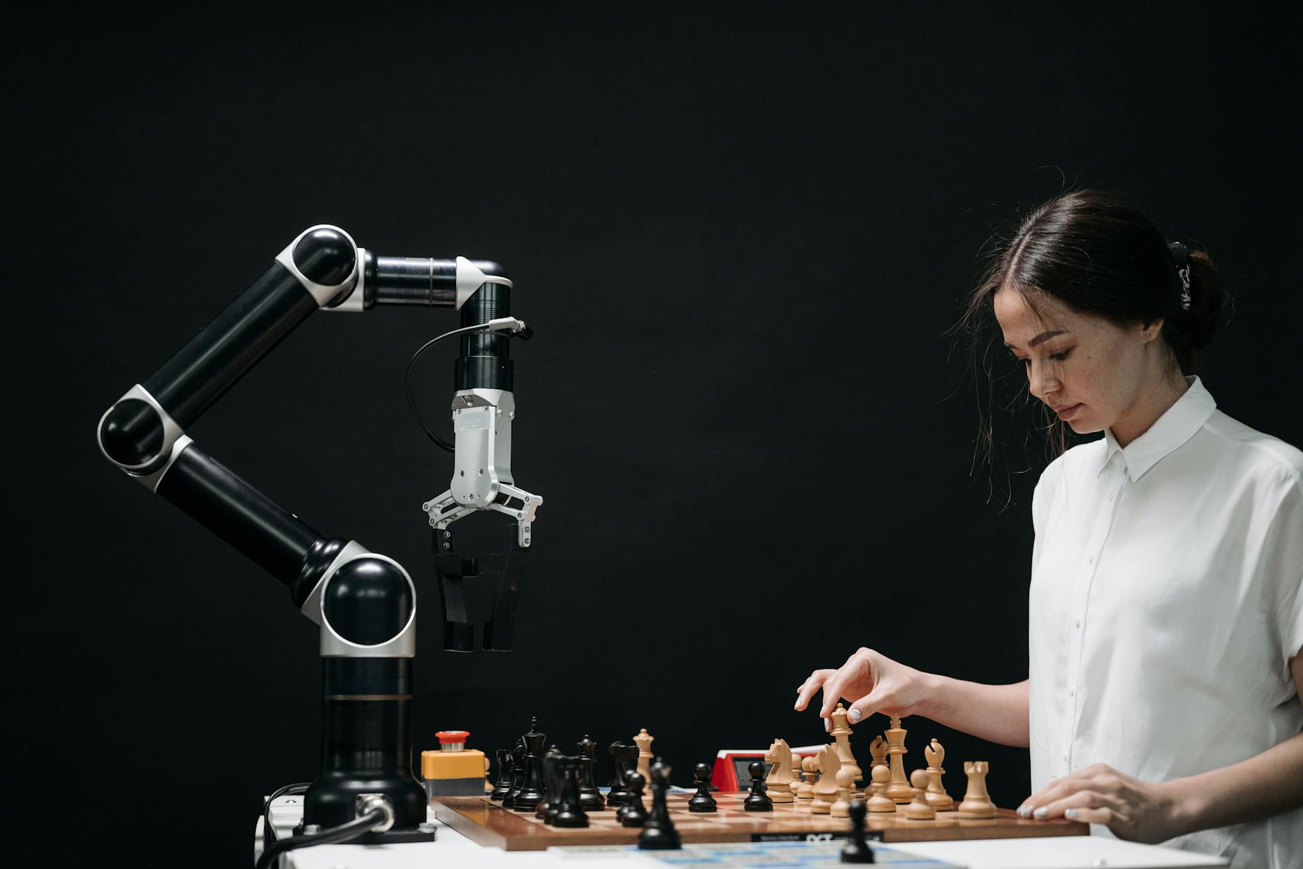 woman in white shirt playing chess against a robot